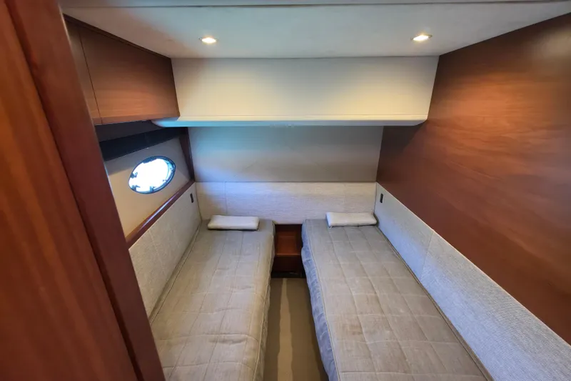  Yacht Photos Pics Luxurious twin cabin interior on a 2017 Princess 52 yacht, featuring elegant wood paneling.