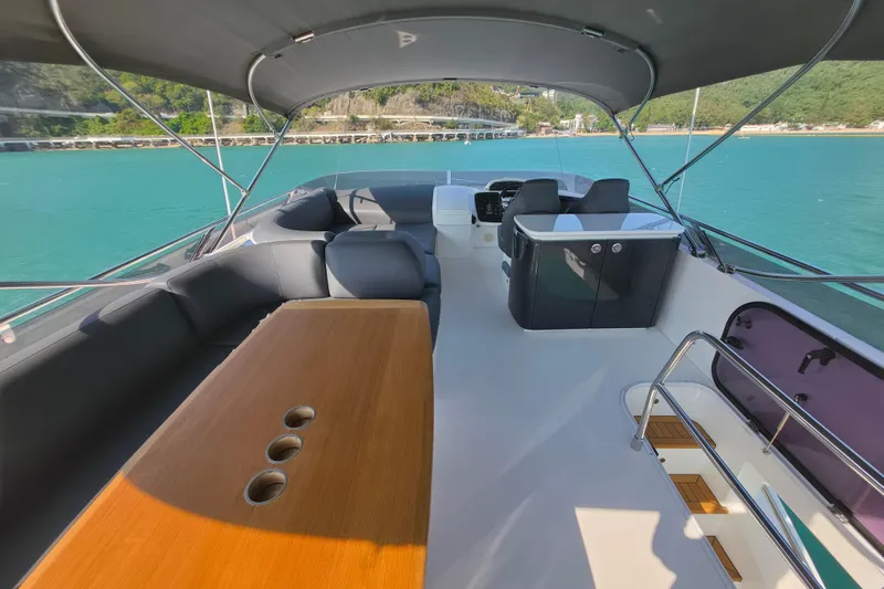  Yacht Photos Pics Luxurious 2017 Princess 52 yacht deck with seating, table, and helm, overlooking turquoise waters.