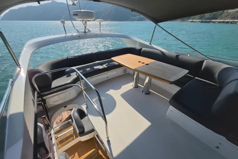  Yacht Photos Pics Luxurious 2017 Princess 52 yacht deck with seating and table, overlooking serene waters.