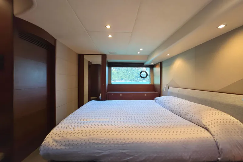  Yacht Photos Pics Luxurious bedroom interior of 2017 Princess 52 yacht with elegant bedding and window view.