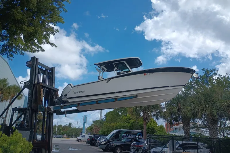 Yacht Photos Pics 2020 Blackfin 272 CC boat lifted by forklift under a blue sky.