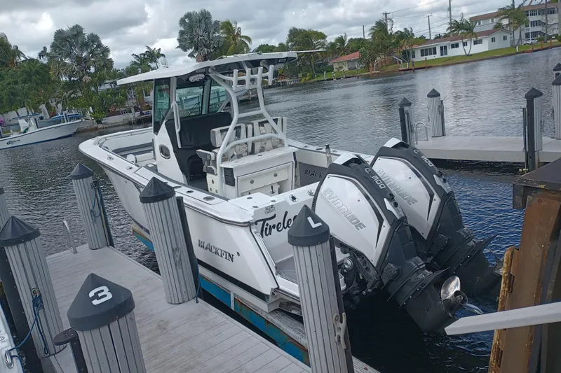  Yacht Photos Pics 2020 Blackfin 272 CC boat docked with dual Evinrude engines, surrounded by water and palm trees.
