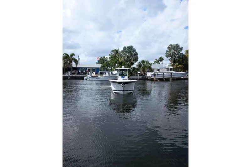  Yacht Photos Pics 2020 Blackfin 272 CC boat on calm water near docks and palm trees.