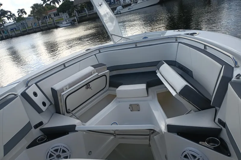  Yacht Photos Pics 2020 Blackfin 272 CC boat interior with cushioned seating and storage, docked by the water.