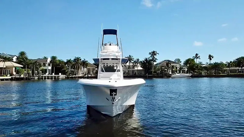 Troublemaker Yacht Photos Pics 2020 Invincible 39 Open Fisherman boat on calm water, surrounded by waterfront homes.