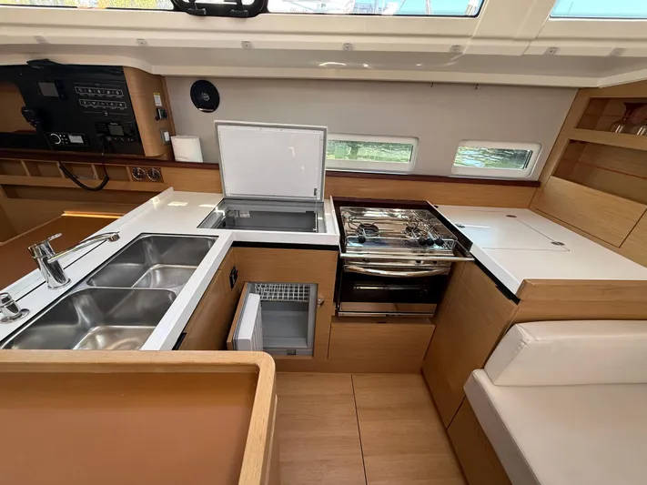 Ceci Yacht Photos Pics Modern kitchen interior of 2021 Jeanneau Sun Odyssey 410 yacht with sleek appliances and wood finish.