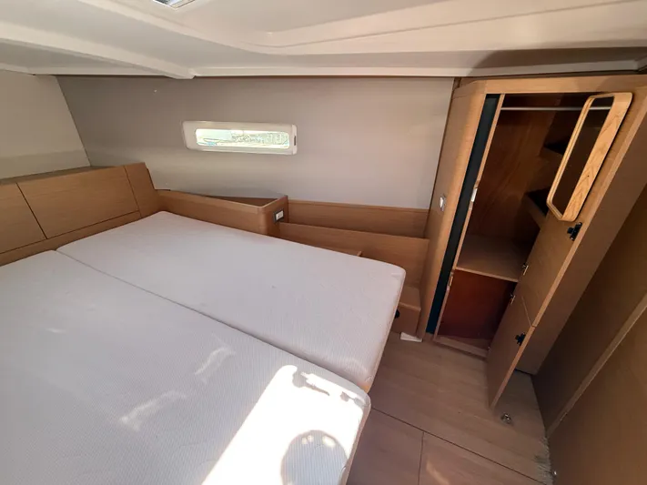 Ceci Yacht Photos Pics Interior cabin of 2021 Jeanneau Sun Odyssey 410 yacht, featuring bed and wooden storage.