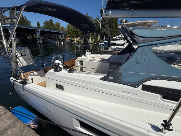 Ceci Yacht Photos Pics 2021 Jeanneau Sun Odyssey 410 sailboat docked at marina, featuring sleek design and blue canopy.