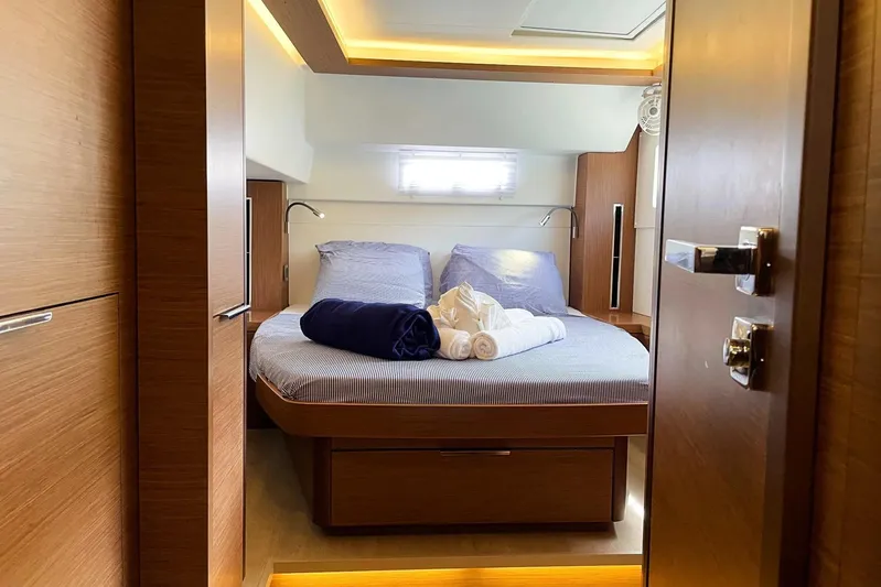 Spanky's Gang Yacht Photos Pics Luxurious cabin interior of 2021 Lagoon 46 yacht with cozy bedding and ambient lighting.