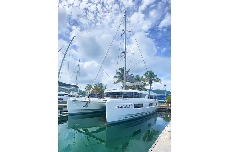 Spanky's Gang Yacht Photos Pics 2021 Lagoon 46 catamaran docked in a marina under a partly cloudy sky.