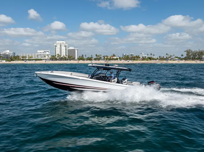  Yacht Photos Pics 2022 Nor-Tech 390 Sport Center Console cruising on ocean near city skyline.