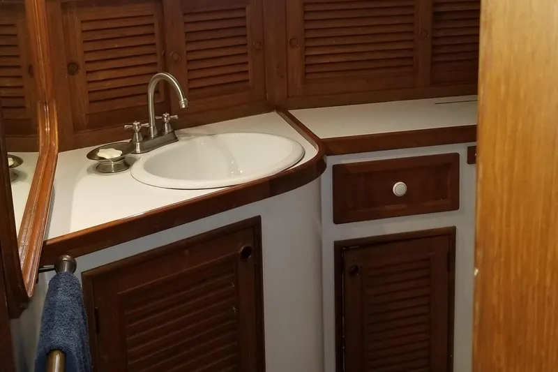  Yacht Photos Pics 1982 Cheoy Lee 52 yacht bathroom with wooden cabinets and a white sink.