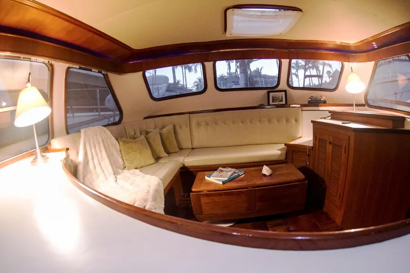  Yacht Photos Pics Luxurious interior of 1982 Cheoy Lee 52 yacht with cozy seating and elegant wood finishes.