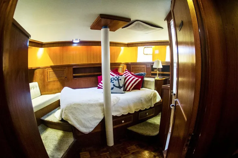  Yacht Photos Pics Luxurious cabin interior of 1982 Cheoy Lee 52 yacht with cozy bed and nautical decor.