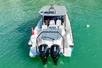 2020 Axopar 28 T-Top boat on clear green water, rear view with dual engines.