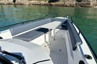 2020 Axopar 28 T-Top boat with seating and table on calm water.