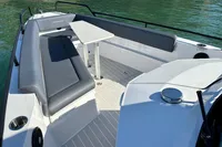 2020 Axopar 28 T-Top boat with sleek seating and table on calm water.