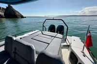 2020 Axopar 28 T-Top boat on calm water with scenic coastal view.