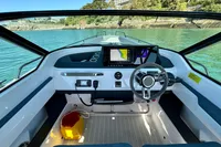 2020 Axopar 28 T-Top boat cockpit with modern navigation system on a serene waterway.