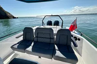 2020 Axopar 28 T-Top boat with seating, ocean view, and flag.
