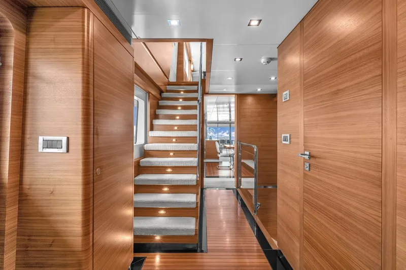 Sea Axis Yacht Photos Pics Luxurious wooden interior of 1988 Heesen Trideck yacht with modern staircase and lighting.