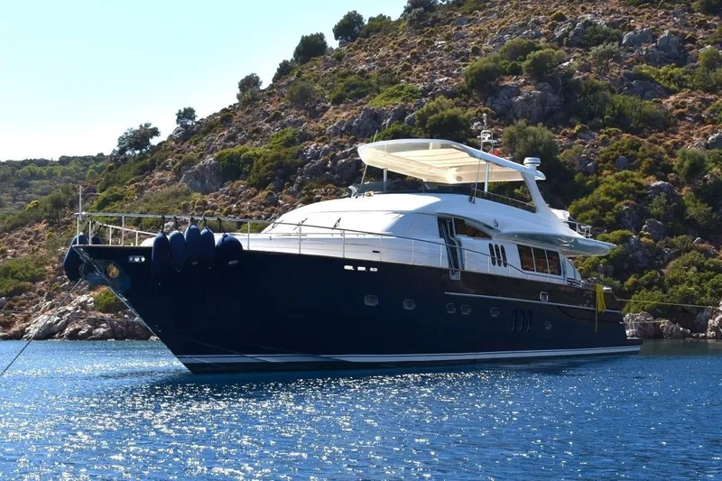  Yacht Photos Pics Luxury Princess 25M yacht from 2005 anchored near rocky coastline.