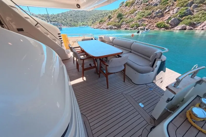  Yacht Photos Pics Luxurious 2005 Princess 25M yacht deck with dining area, overlooking serene turquoise waters.