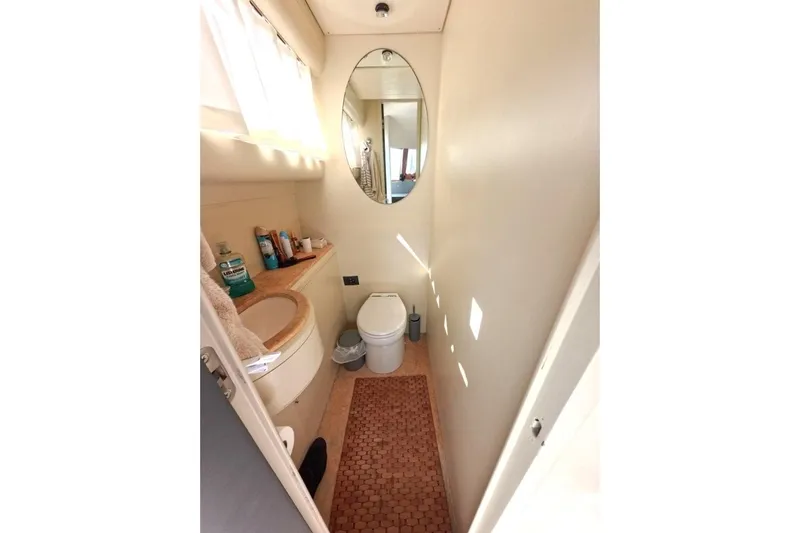  Yacht Photos Pics Compact bathroom in a 2005 Princess 25M yacht, featuring a mirror and modern amenities.