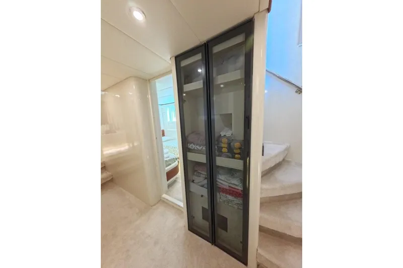  Yacht Photos Pics Interior of 2005 Princess 25M yacht with glass cabinet and staircase.