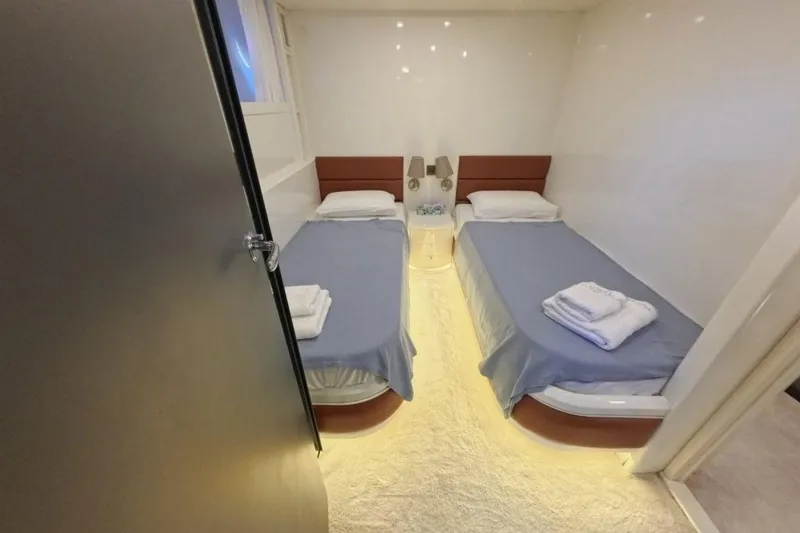  Yacht Photos Pics Twin cabin room in 2005 Princess 25M yacht, featuring cozy beds and ambient lighting.