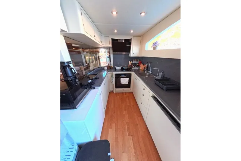  Yacht Photos Pics Modern kitchen interior on a 2005 Princess 25M yacht, featuring sleek cabinetry and appliances.