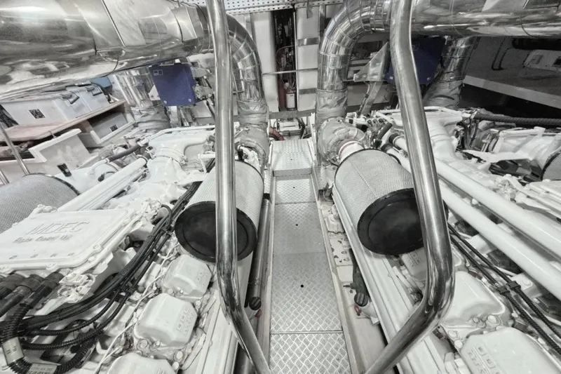  Yacht Photos Pics Engine room of a 2005 Princess 25M yacht, featuring dual engines and metallic piping.