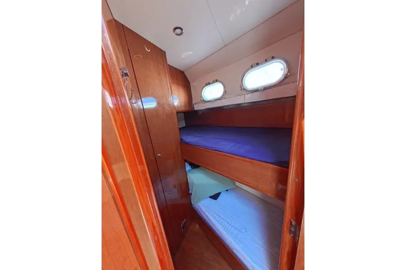  Yacht Photos Pics Interior of 2005 Princess 25M yacht with wooden bunk beds and portholes.