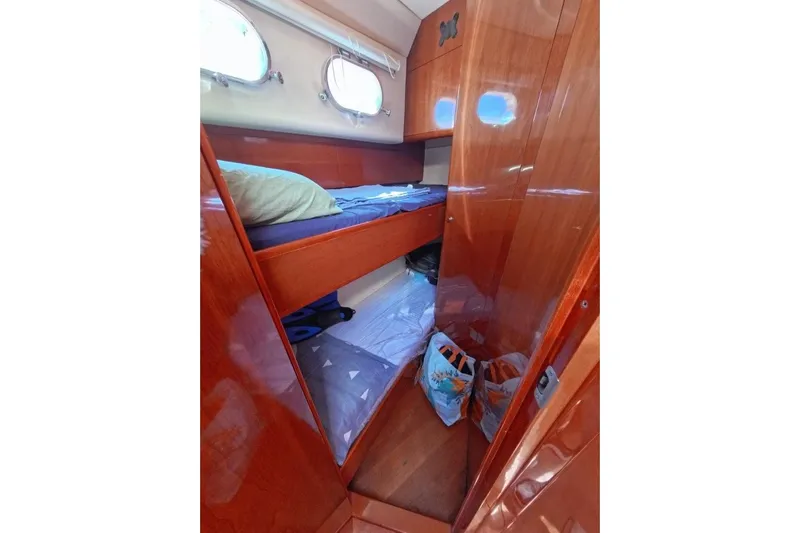  Yacht Photos Pics Cozy cabin interior of 2005 Princess 25M yacht with wooden finish and bunk bed.
