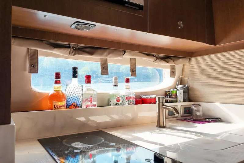  Yacht Photos Pics 2017 Sea Ray Sundancer 350 interior with kitchen counter and liquor bottles by window.