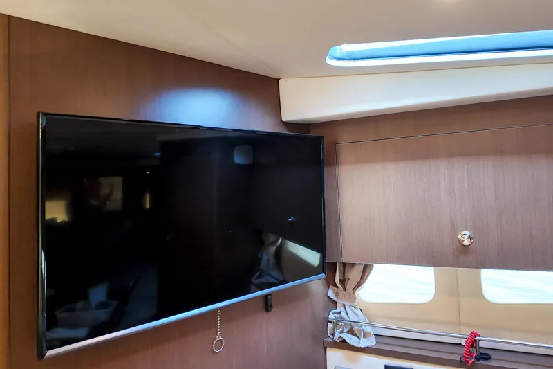  Yacht Photos Pics Interior of 2017 Sea Ray Sundancer 350 with mounted TV and wooden cabinetry.