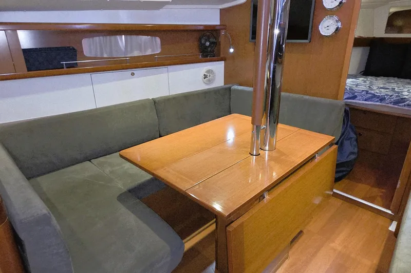  Yacht Photos Pics Interior of 2013 Beneteau Oceanis 37 sailboat with cozy seating and wooden table.