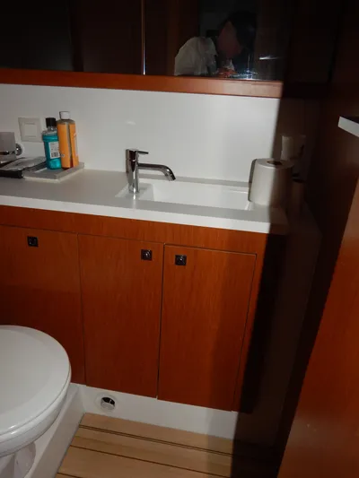  Yacht Photos Pics 2015 Beneteau Sense 55 bathroom with wooden cabinetry and modern fixtures.