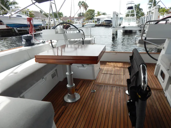  Yacht Photos Pics 2015 Beneteau Sense 55 yacht cockpit with wooden deck and seating area.
