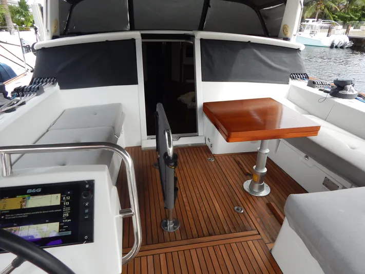  Yacht Photos Pics Beneteau Sense 55 yacht cockpit, 2015 model, featuring teak flooring and a wooden table.