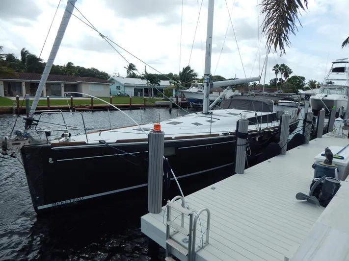  Yacht Photos Pics 2015 Beneteau Sense 55 yacht docked at marina, sleek black hull, modern design.
