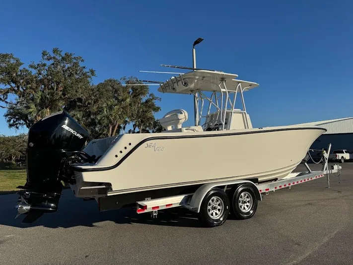  Yacht Photos Pics 2023 SeaVee 290B boat on trailer, side view, clear sky background.