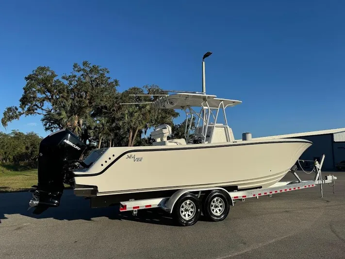  Yacht Photos Pics 2023 SeaVee 290B boat on trailer, parked outdoors under clear blue sky.