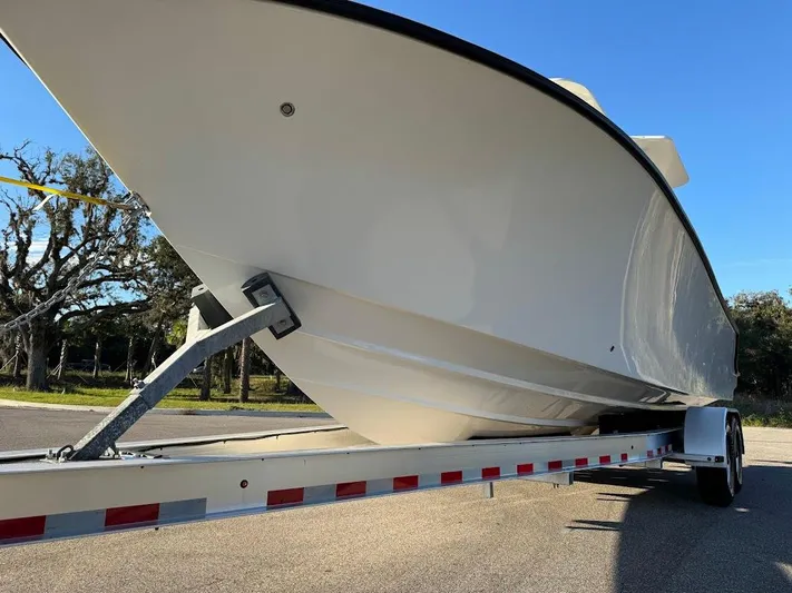  Yacht Photos Pics 2023 SeaVee 290B boat on trailer, side view under clear blue sky.
