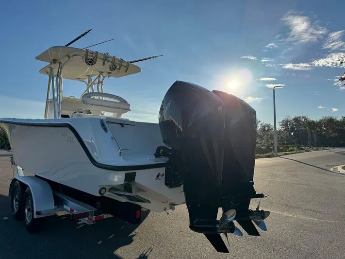  Yacht Photos Pics 2023 SeaVee 290B boat with dual outboard engines on a trailer, sunlit background.