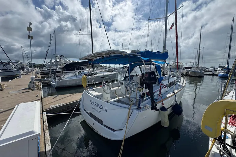 Sea Ranch II Yacht Photos Pics 2018 Jeanneau Sun Odyssey 389 sailboat docked at marina under cloudy sky.