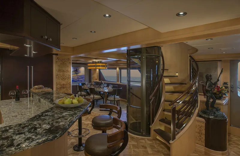 Cazador Yacht Photos Pics Luxurious interior of 2019 Nordlund Expedition Yachtfisher with modern kitchen, dining area, and spiral staircase.