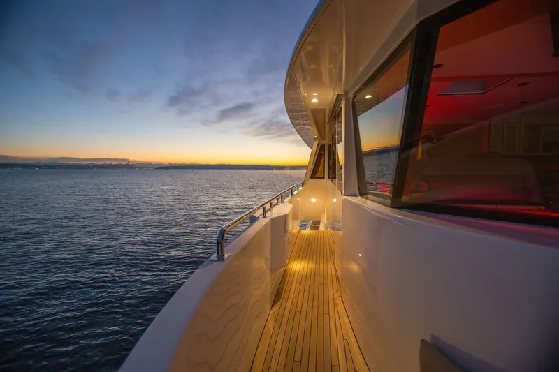 Cazador Yacht Photos Pics 2019 Nordlund Expedition Yachtfisher deck at sunset, overlooking calm ocean waters.