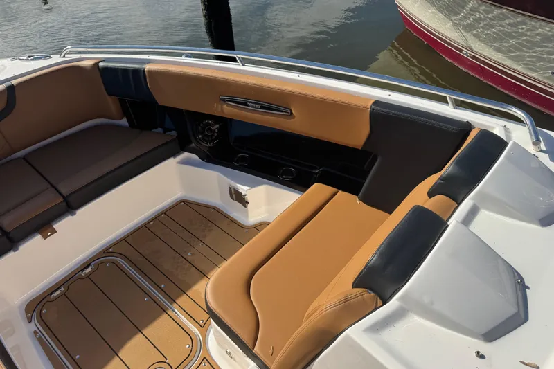  Yacht Photos Pics 2023 Chaparral 347 SSX boat interior with tan and black seating, docked by water.