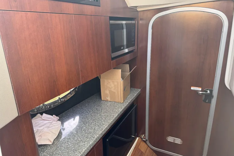  Yacht Photos Pics 2023 Chaparral 347 SSX interior with wood cabinetry and granite countertop.